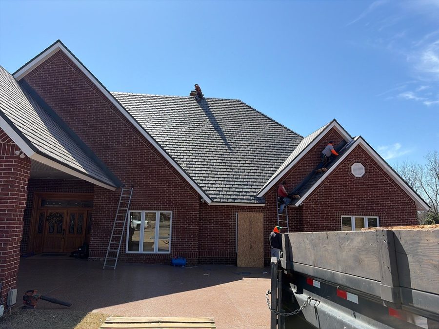 McRay Roofing crew installing a concrete tile roof on a brick home